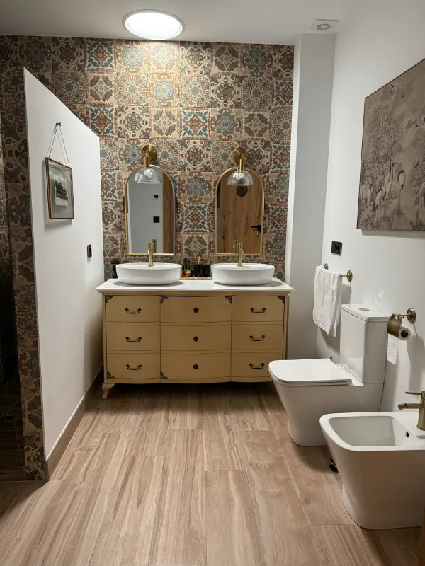 Baño con doble lavabo sobre un mueble de madera