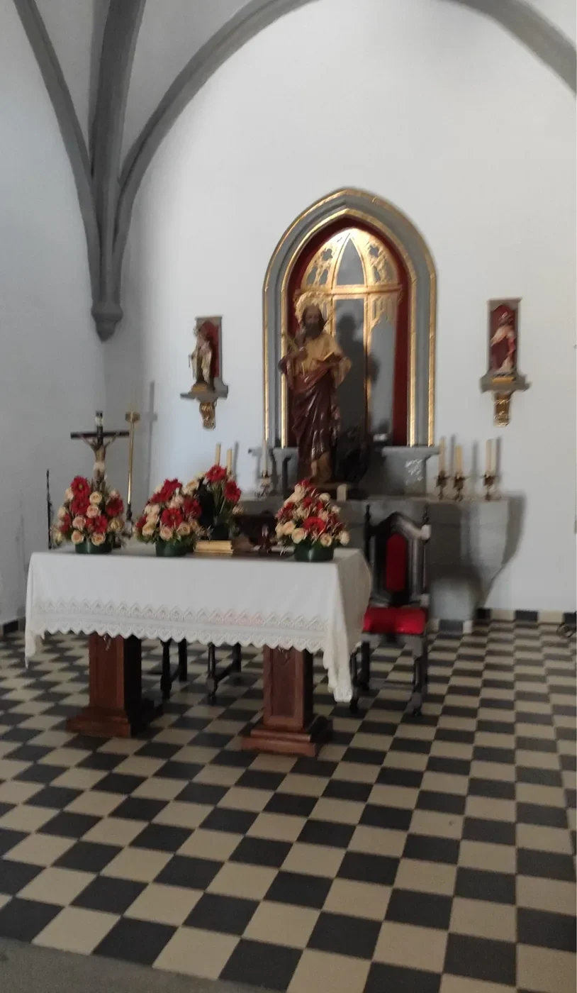 Interior de la ermita de San Bartolomé con el altar y flores
