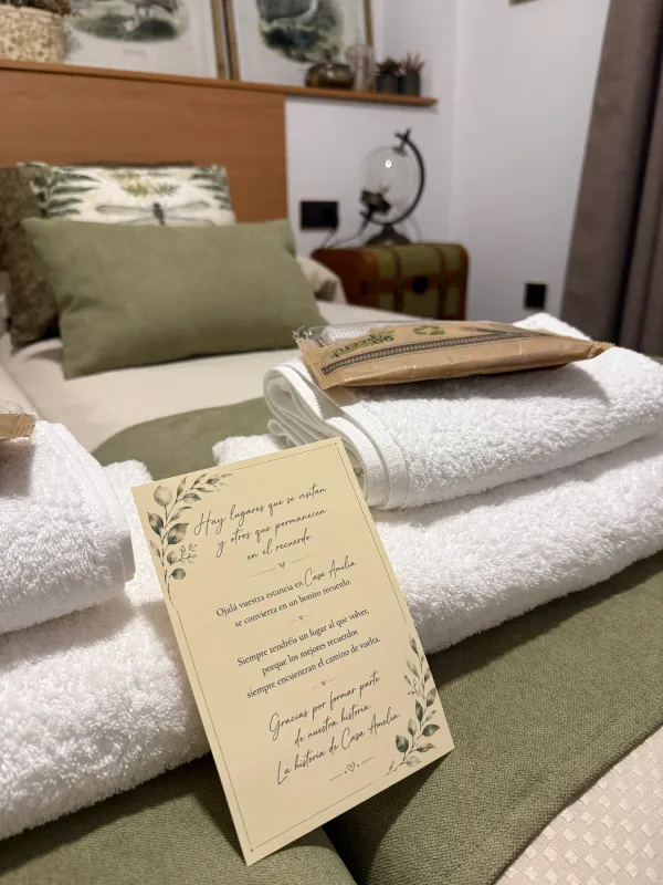 Toallas y tarjeta de bienvenida sobre la cama