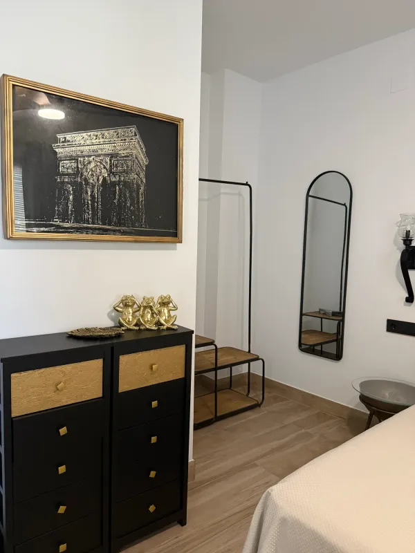 Cómoda negra con detalles dorados y espejo
