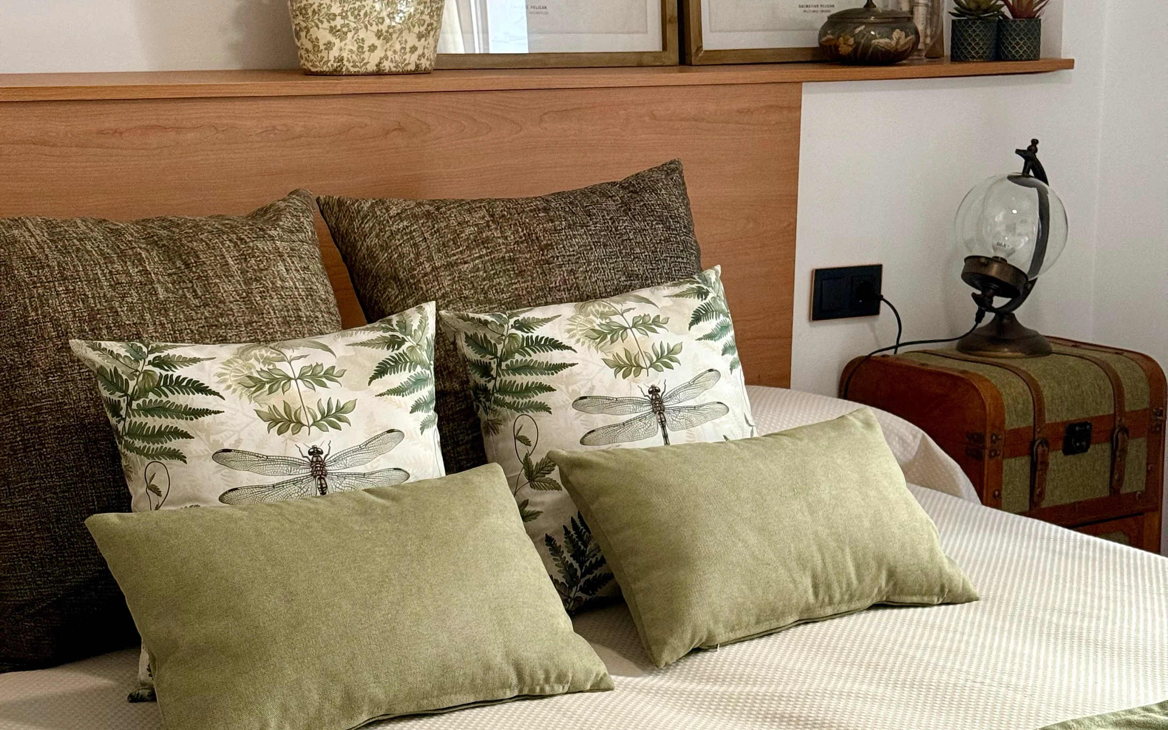 Tête de lit en bois et coussins verts de la chambre 1