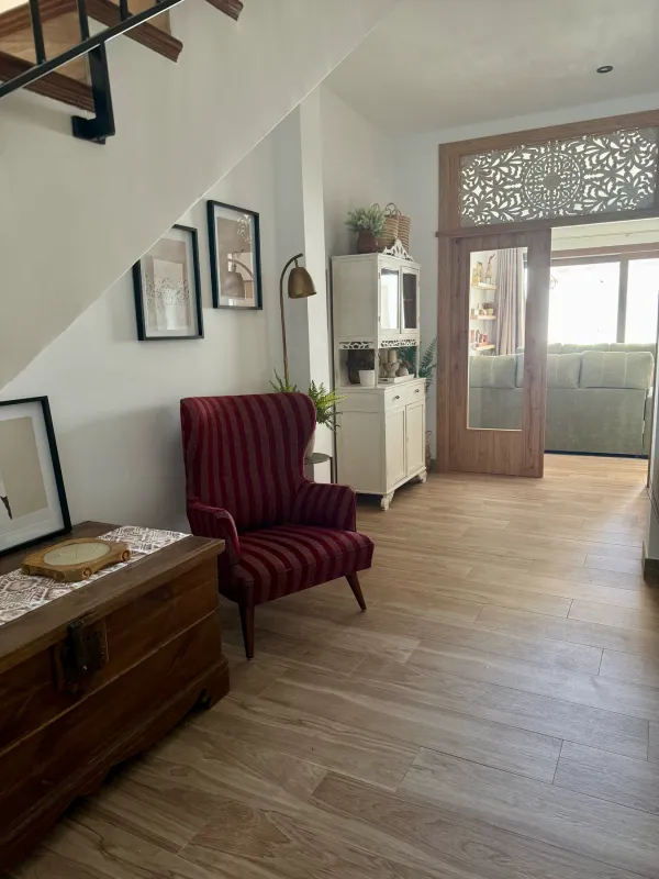 Pasillo de la planta baja con sillón rojo y vitrina