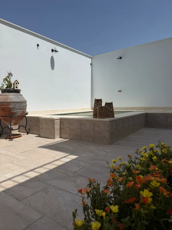 Patio con flores junto al borde de la piscina