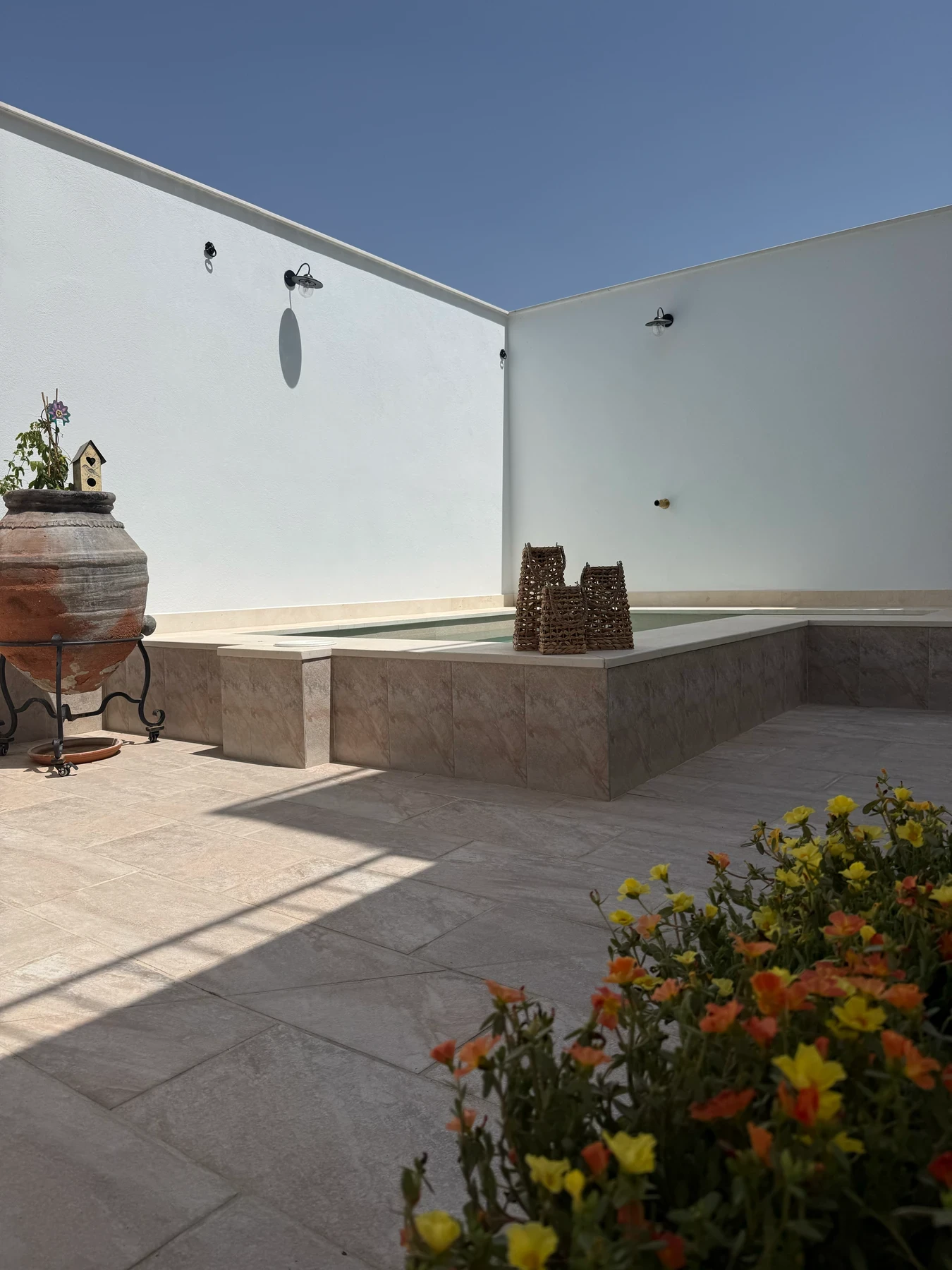Patio avec fleurs au bord de la piscine
