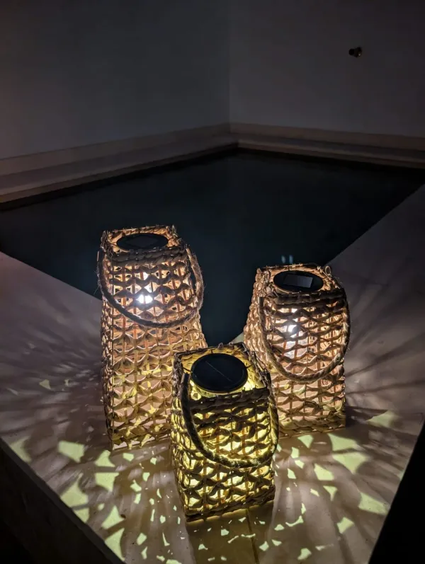 Linternas encendidas junto a la piscina por la noche