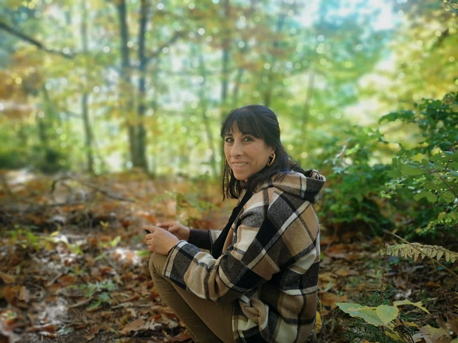 María Ángeles, propietaria de Casa Amelia, sentada entre hojas de otoño