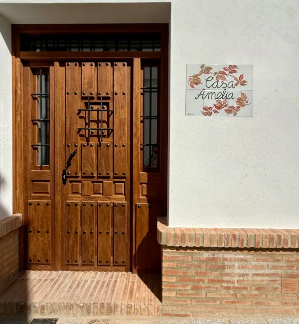Puerta de madera de la casa con la placa de Casa Amelia